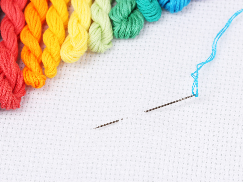 cross stitch guide rainbow floss on white aida with needle