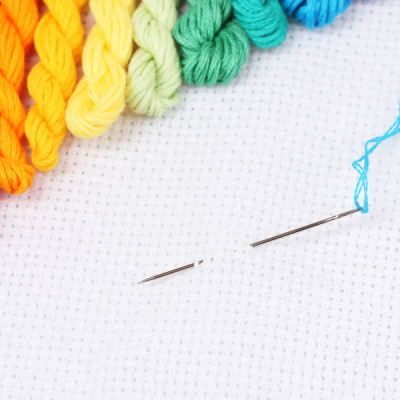 cross stitch guide rainbow floss on white aida with needle